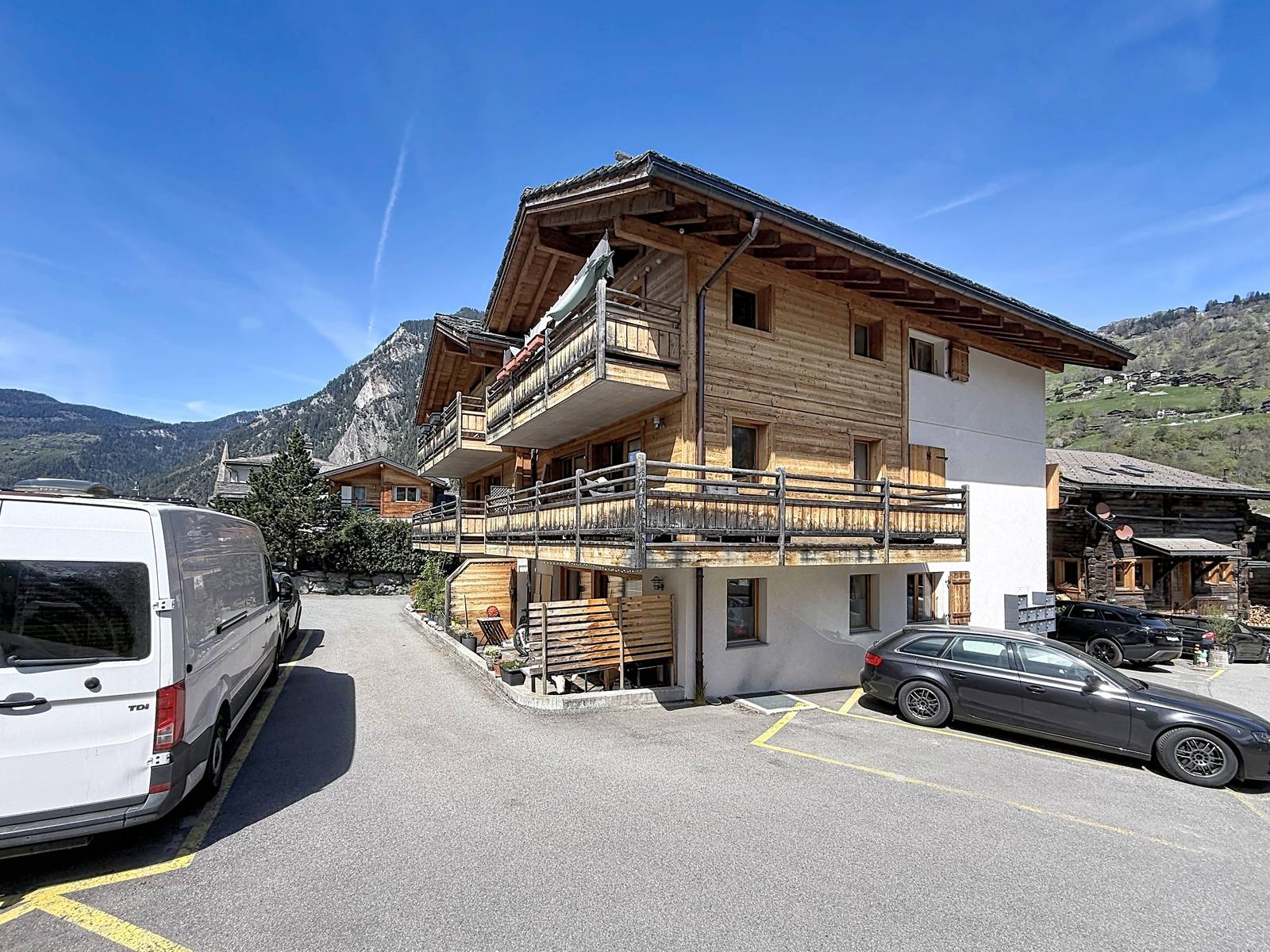 L'accès au chalet depuis le chemin, avec les places de parc extérieures.