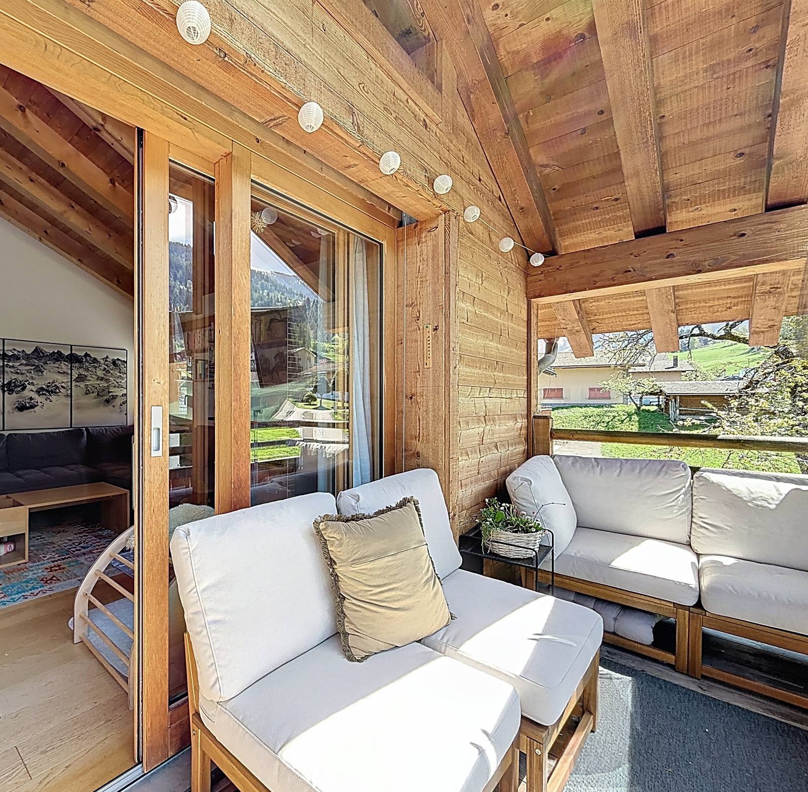 Le balcon aménagé en salon d'été, sous l'avant-toit, ouvert sur la vallée.