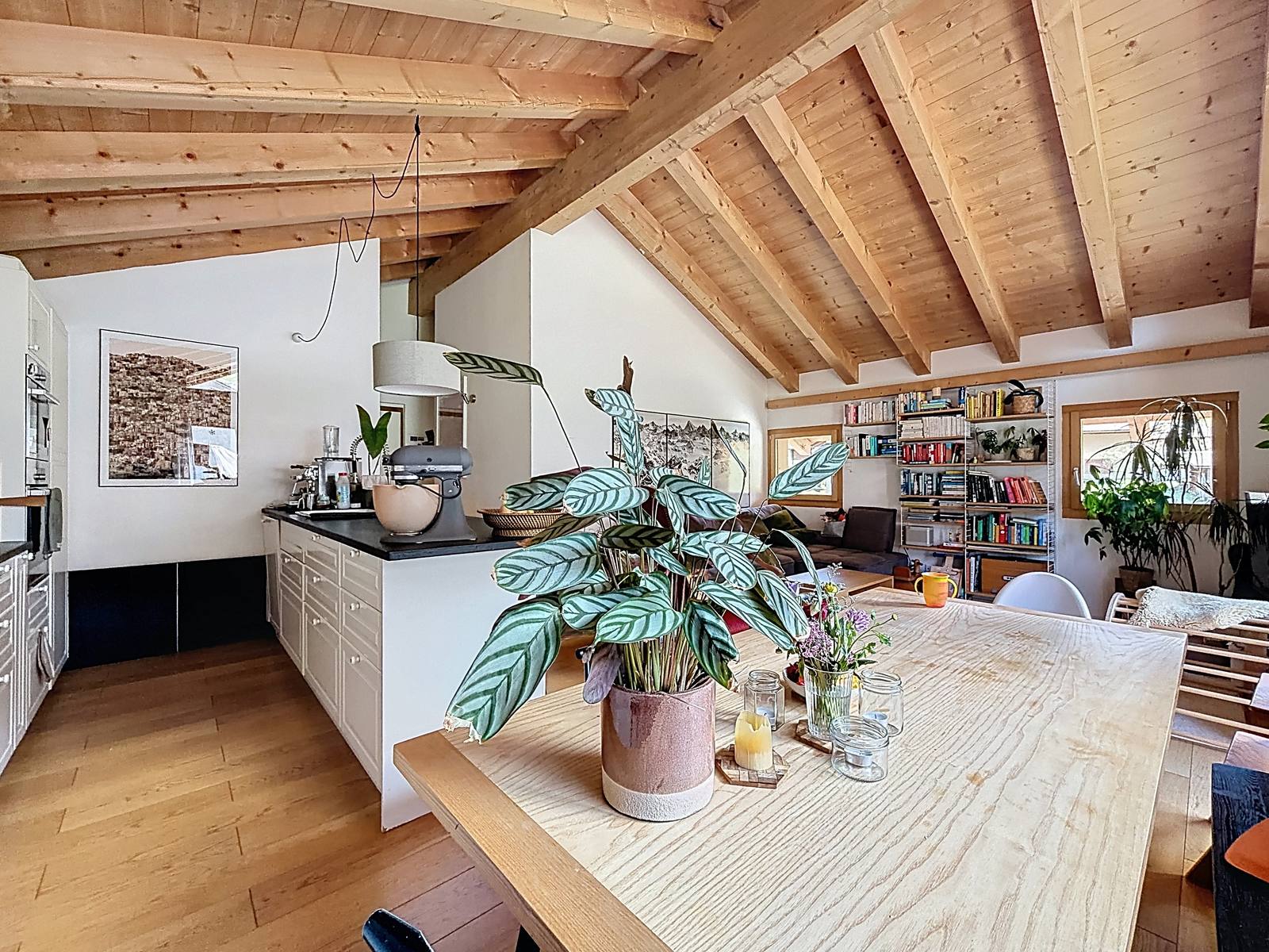 La grande table du coin à manger, sous les poutres, à côté de la cuisine.